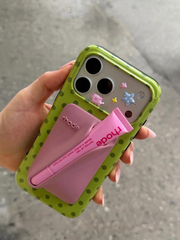Lime green polka dot phone case with pink card holder and camera cutouts