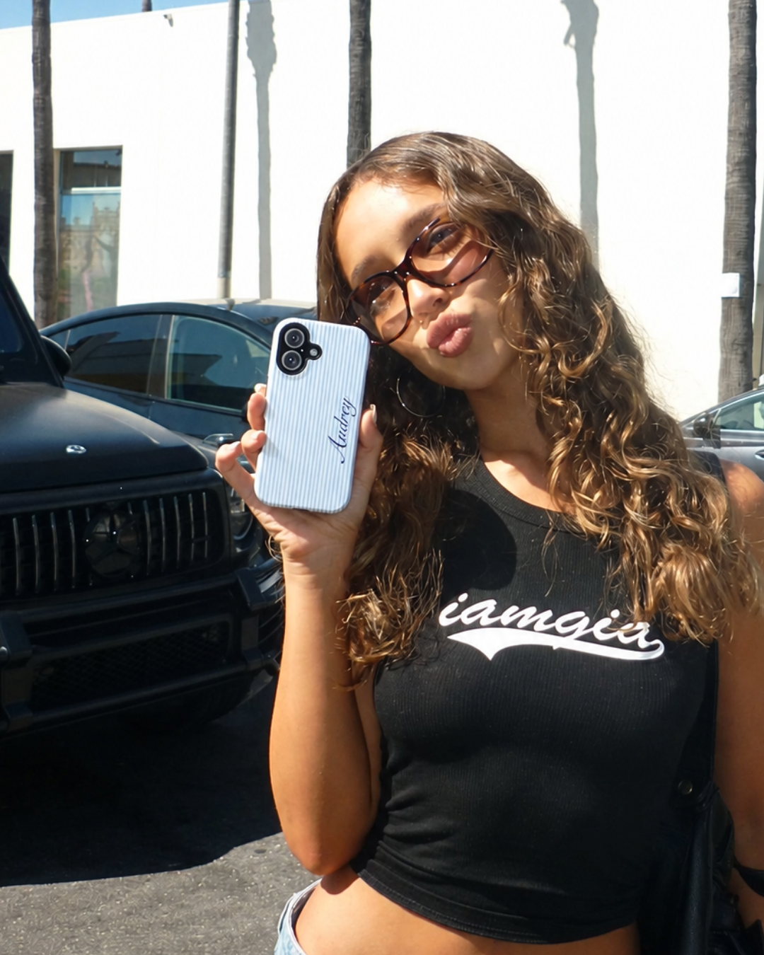 Blue striped phone case with blue cursive custom name, shown from back