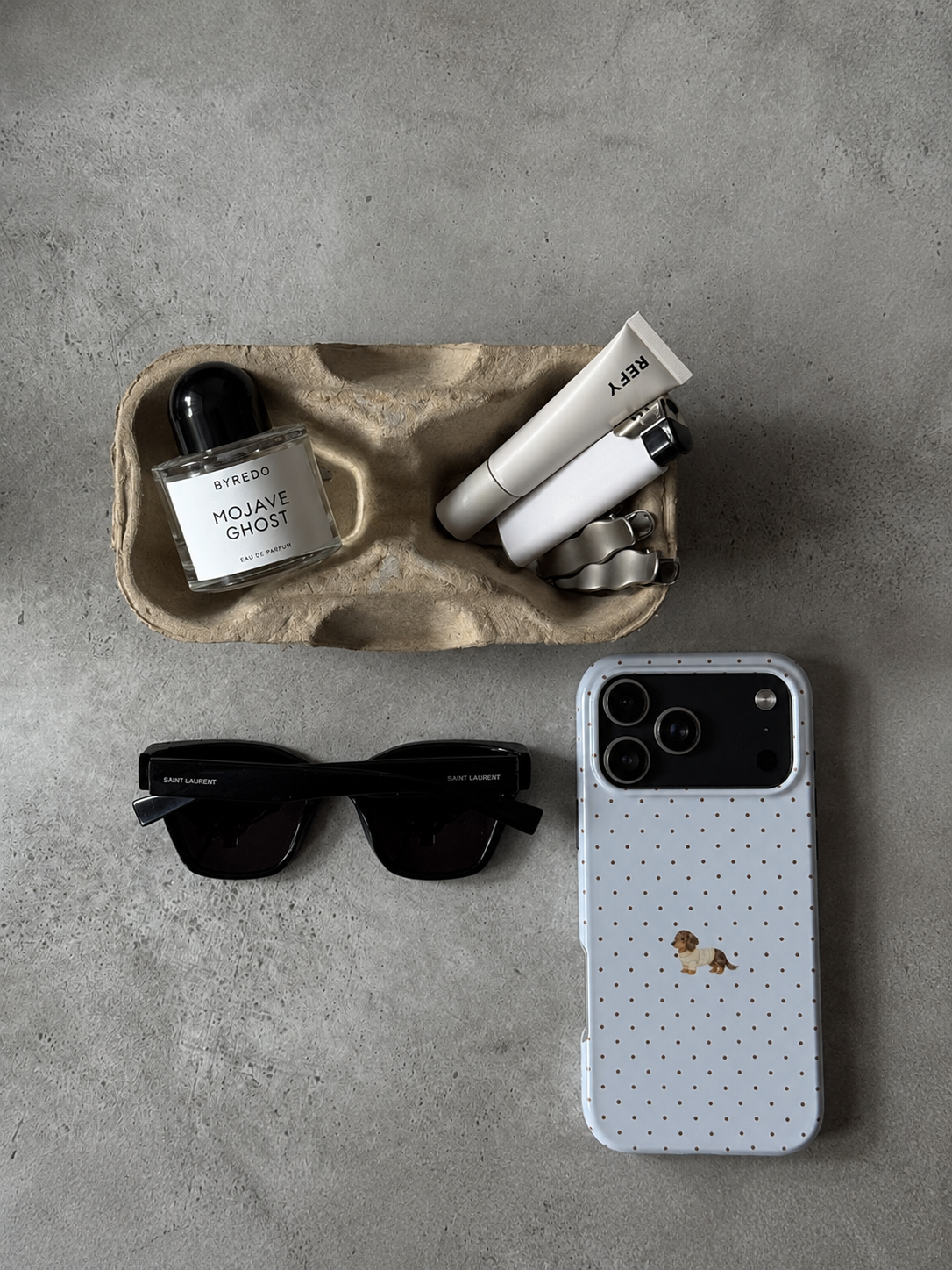 Light blue polka dot phone case with mini dachshund puppy illustration, glossy finish.