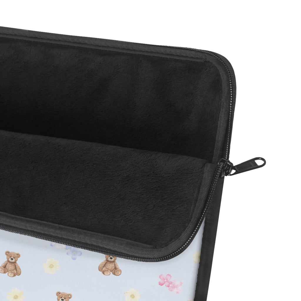 Laptop sleeve interior, dark fabric with zip closure and glimpsed teddy floral print.