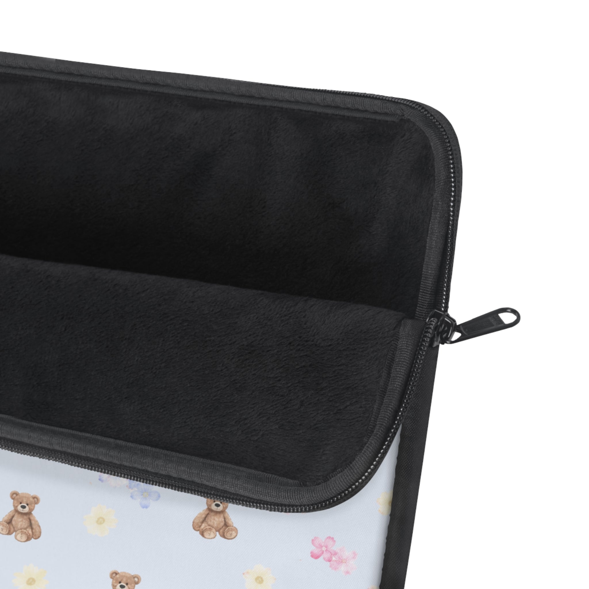 Laptop sleeve interior, dark fabric with zip closure and glimpsed teddy floral print.