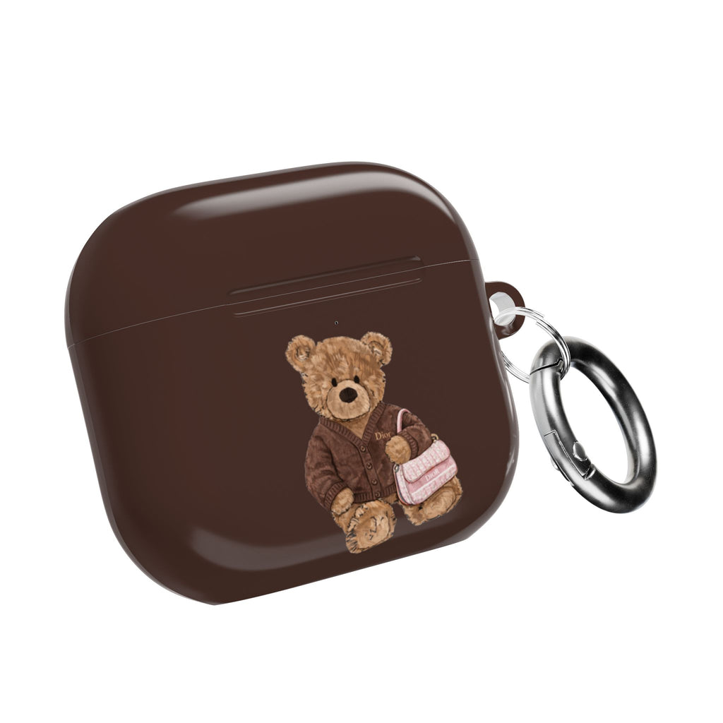 Brown AirPods case with teddy bear appliqué and metal keyring, closed