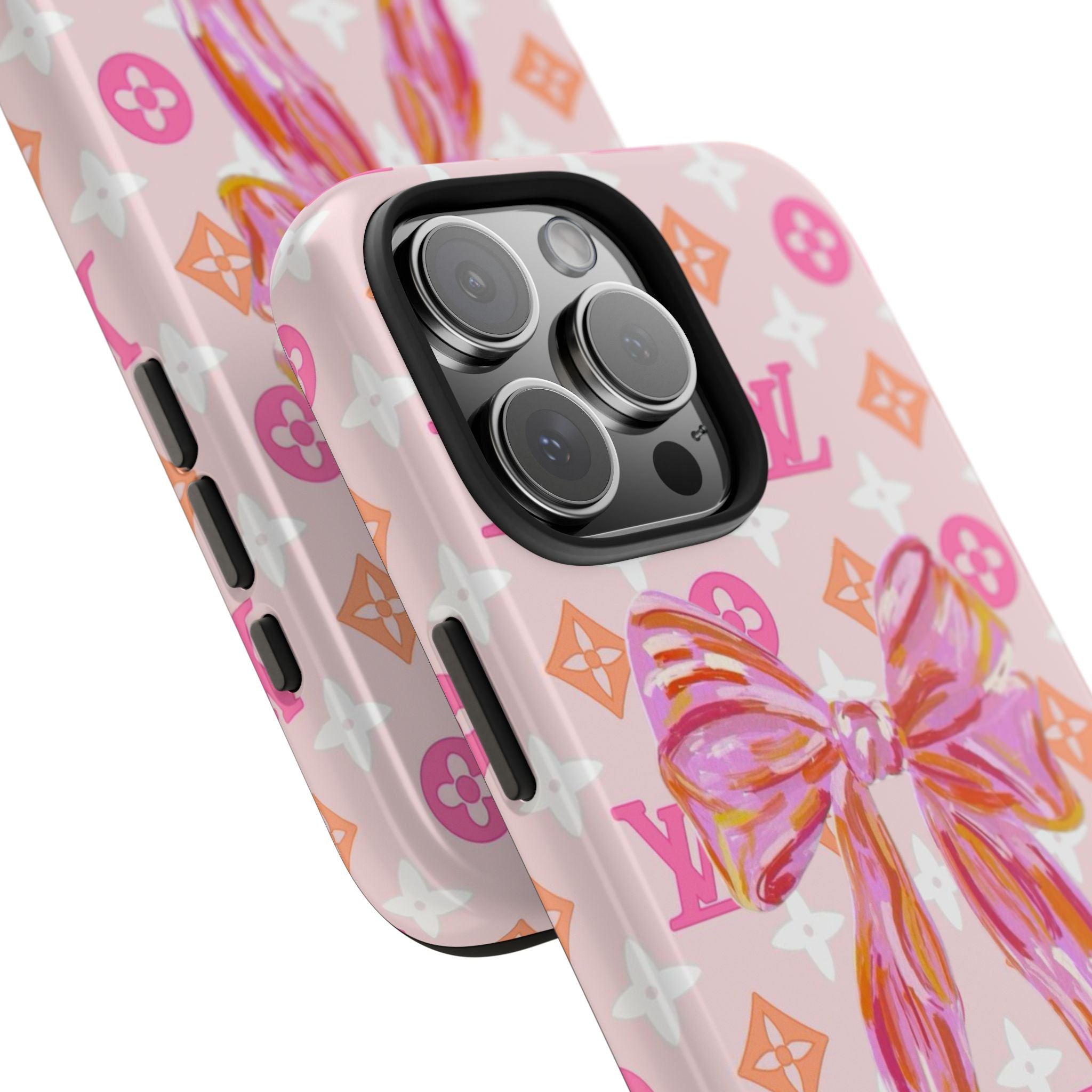 Light pink phone case detail: colorful bow over monogram pattern near camera lenses
