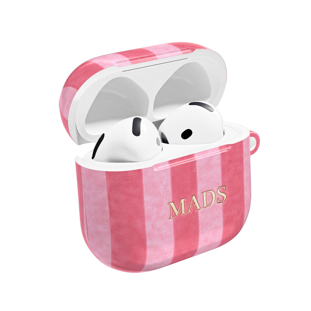 Pink velvet AirPods case with vertical plaid stripes and “MADS” print, open top.