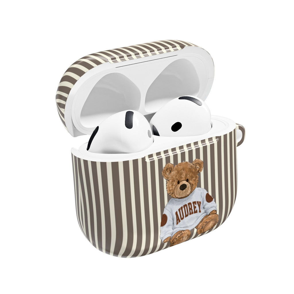 Brown-and-cream striped AirPods case with open lid, white earbuds, teddy bear graphic