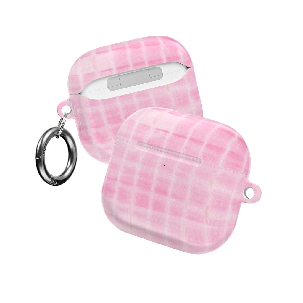 AirPod cases in baby pink shibori tie-dye, one open with key ring