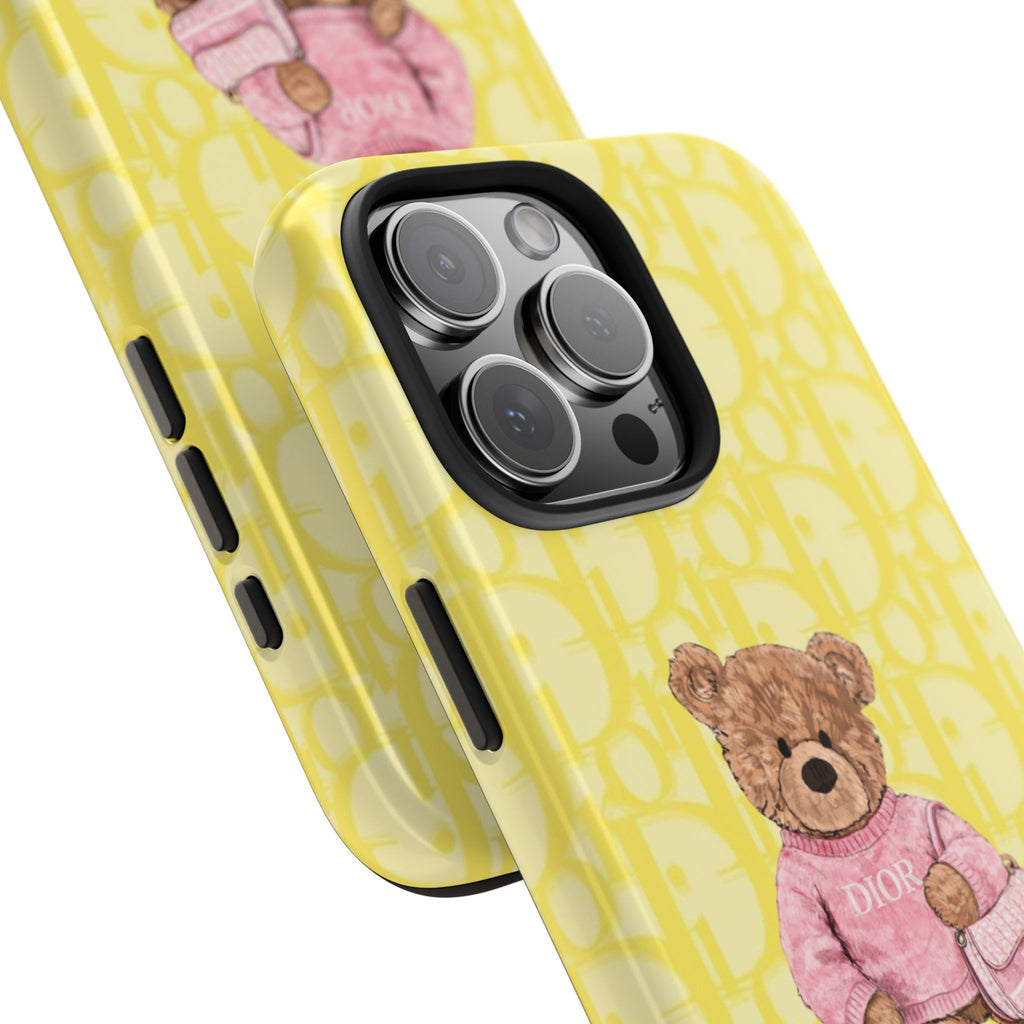 Yellow Dior phone case close-up with teddy bear artwork, pink purse, and camera area