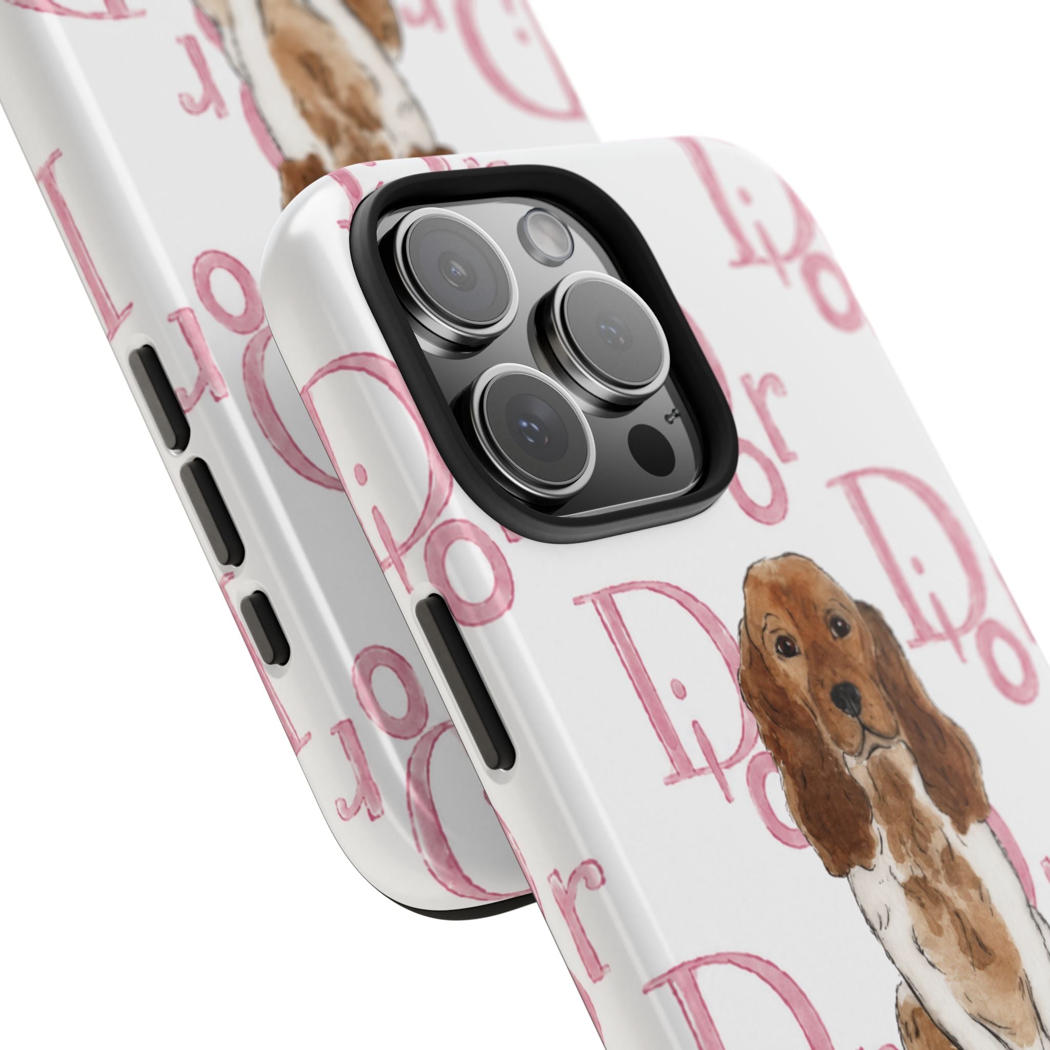 White phone case close-up with repeating pink script pattern and spaniel puppy near cameras