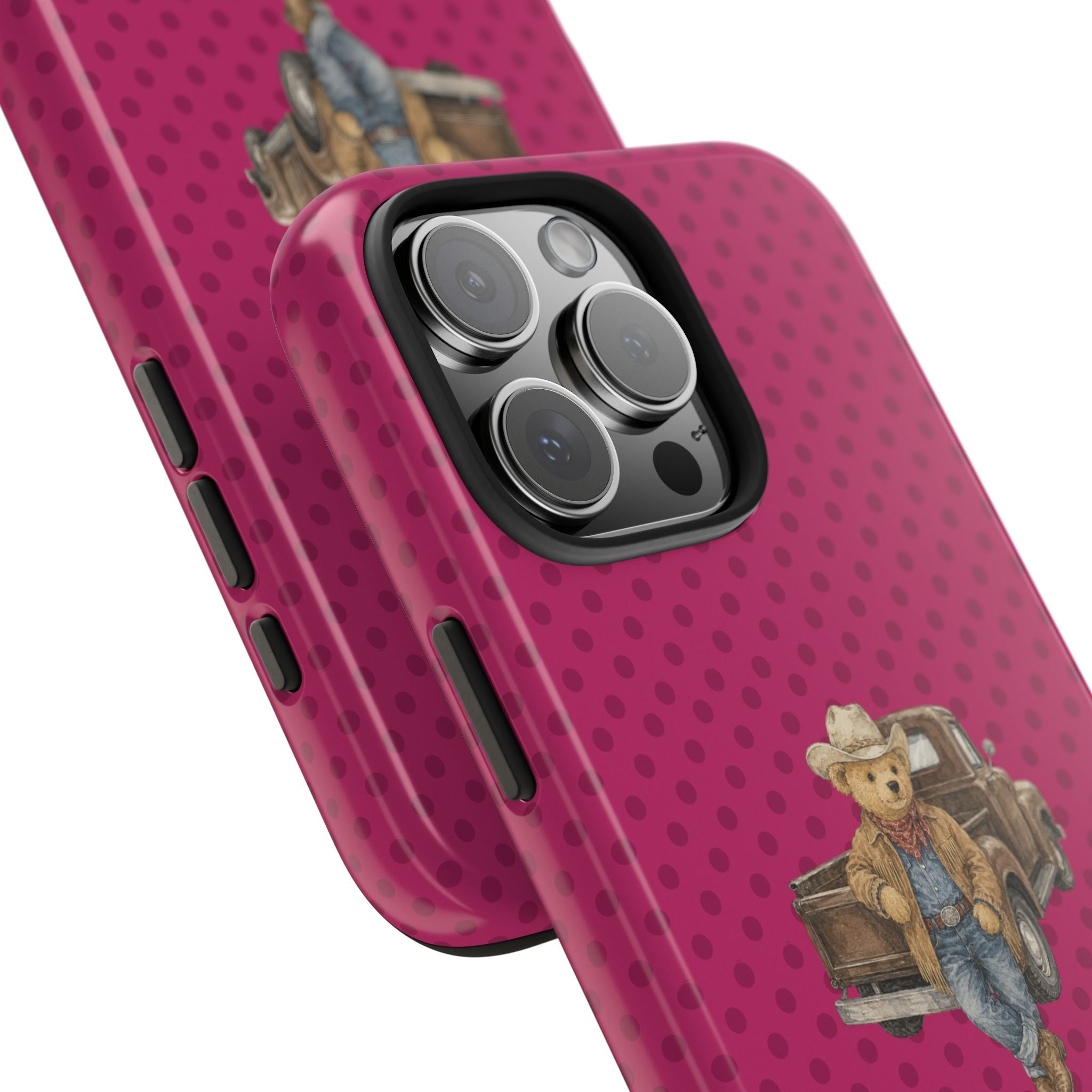 Angled pink polka dot phone case with cowboy teddy bear graphic and camera lens detail.