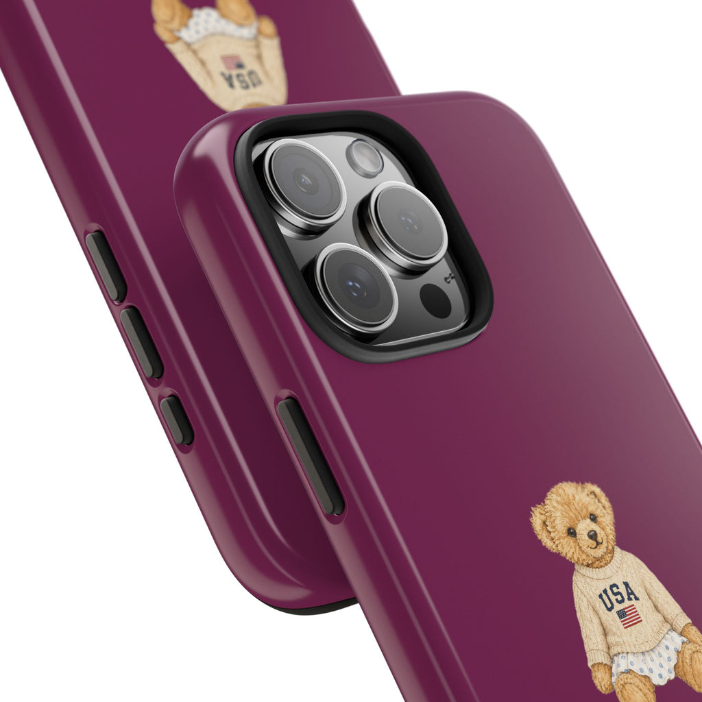 Magenta phone case close-up with teddy bear USA graphic near bottom, side buttons visible