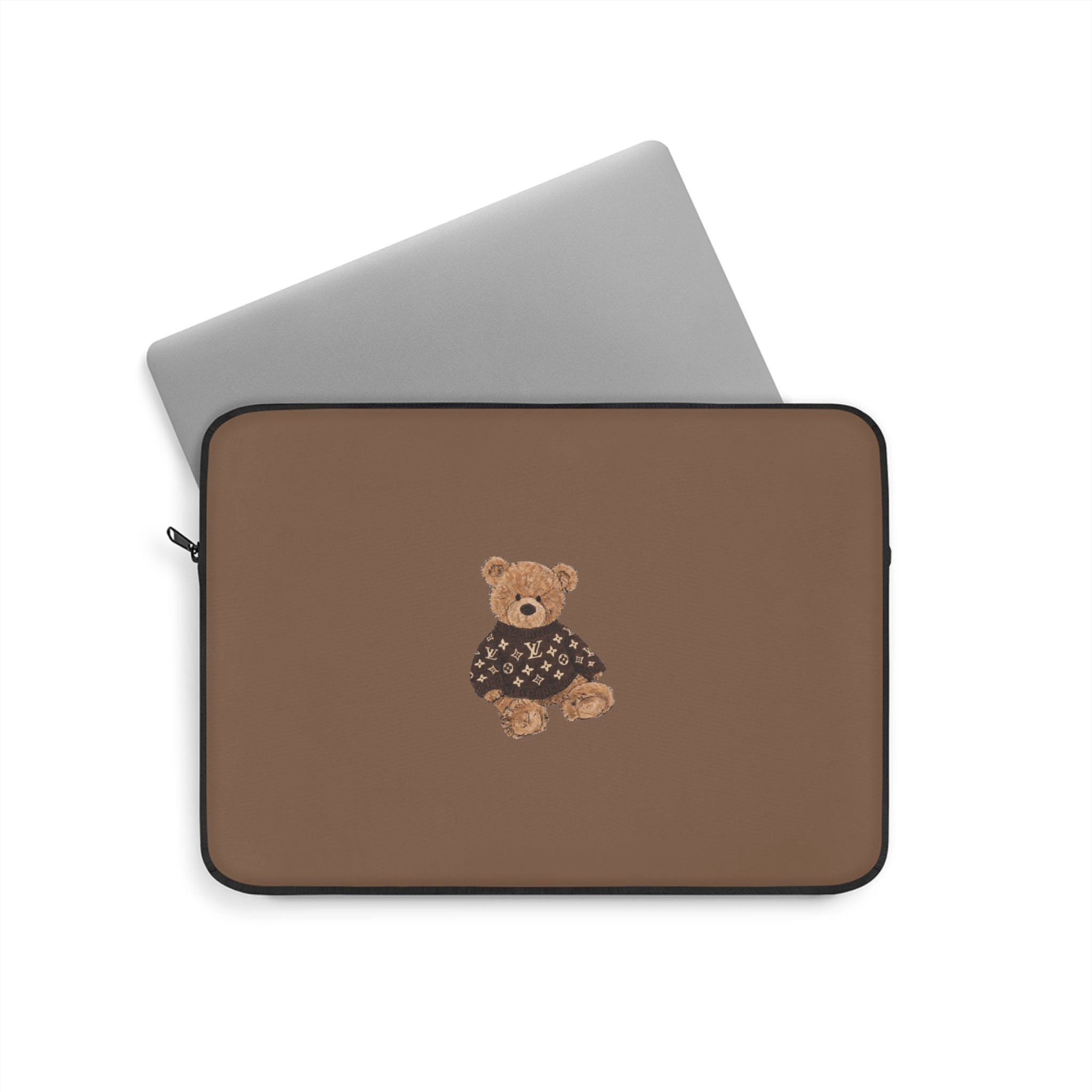 Brown sleeve with teddy bear patch; laptop partially inserted