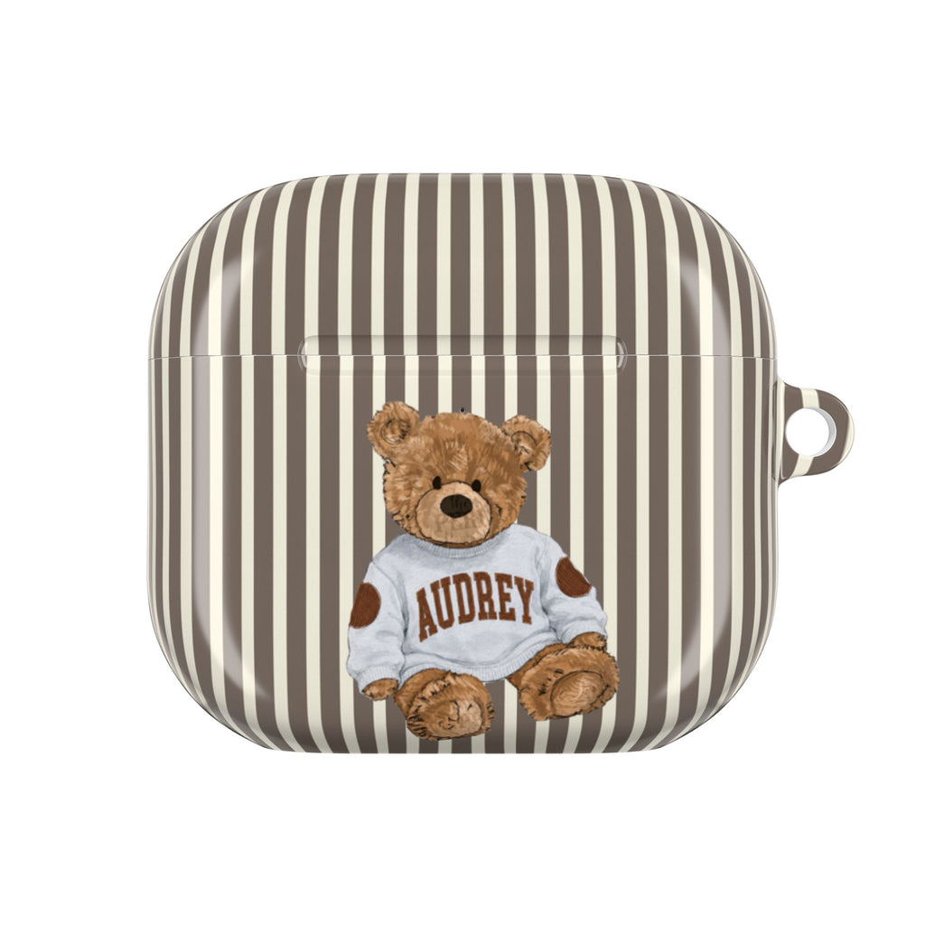 Brown-and-cream striped AirPods case with teddy bear wearing 'AUDREY' shirt