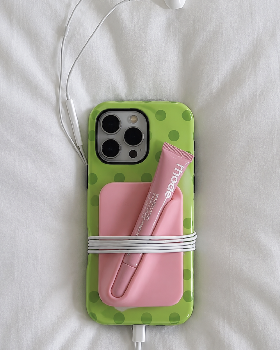 Green polka dot phone case with pink pencil design and camera cutouts
