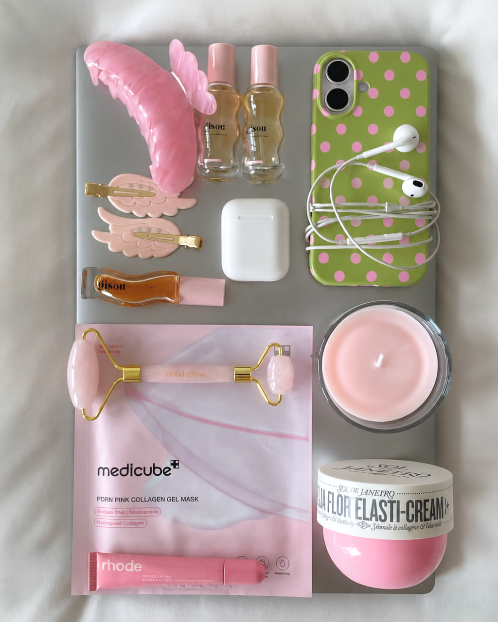 Green phone case with pink polka dots, centered in a flat-lay arrangement