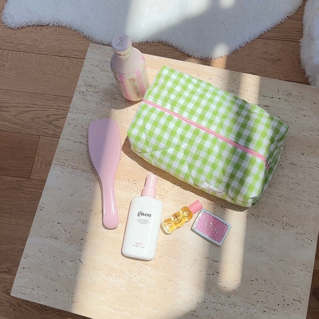 Green gingham pouch with pink-lined opening, showing round compact inside