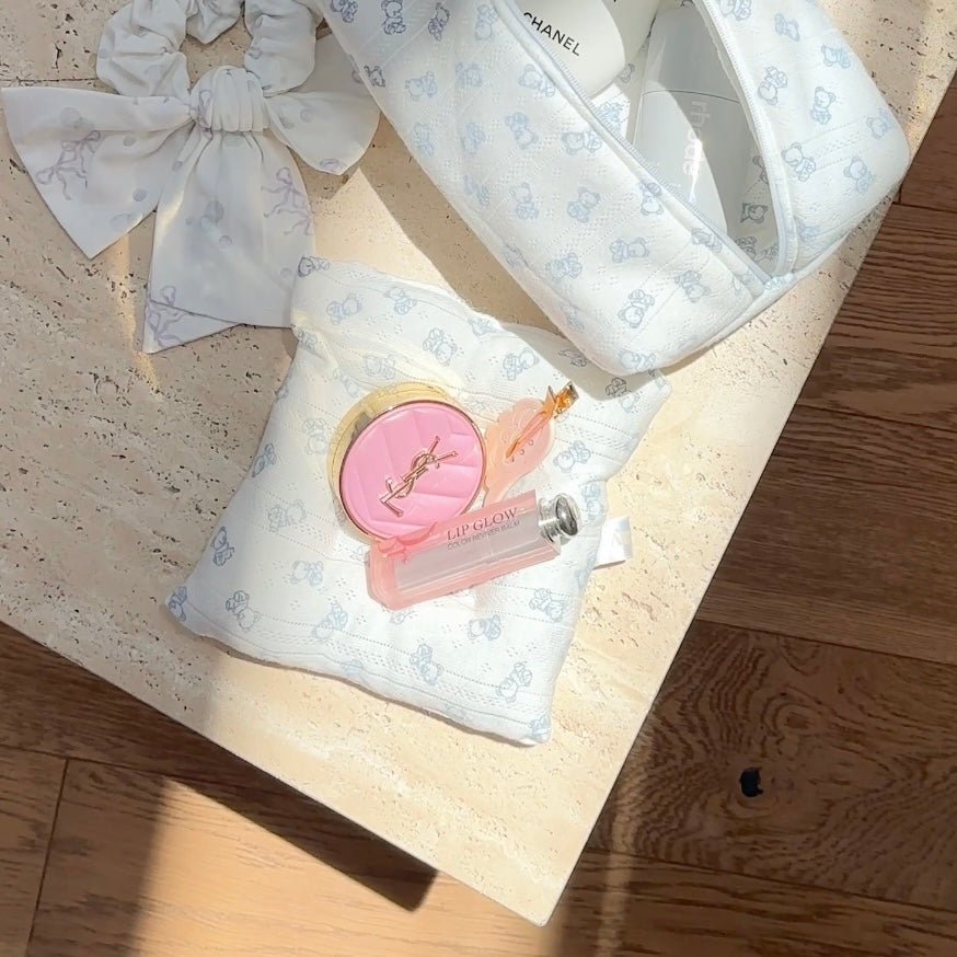 Light blue teddy bear and cloud print coaster with pink circular badge accent
