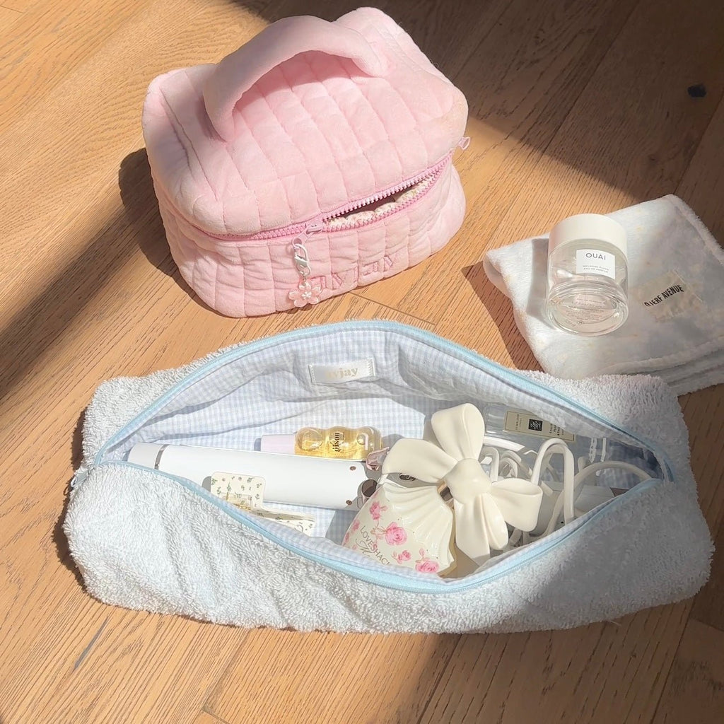 Baby blue terrycloth zip pouch open, showing toiletries and small tools inside