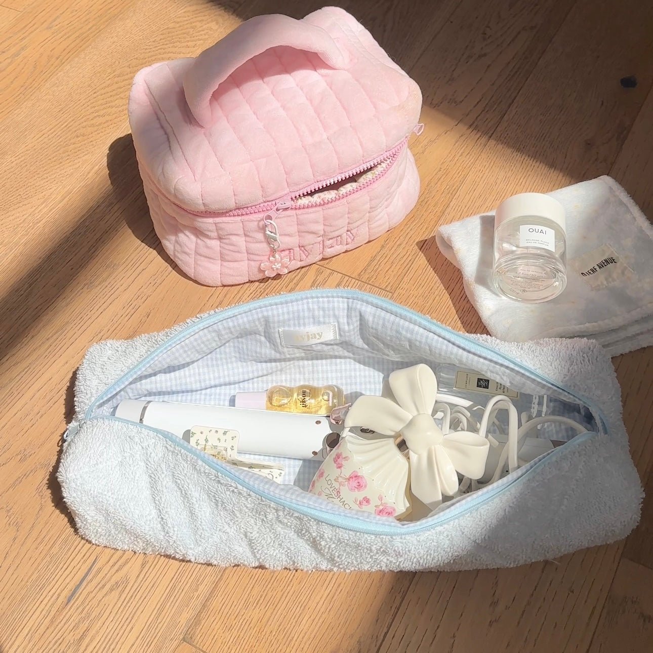 Baby blue terrycloth zip pouch open, showing toiletries and small tools inside