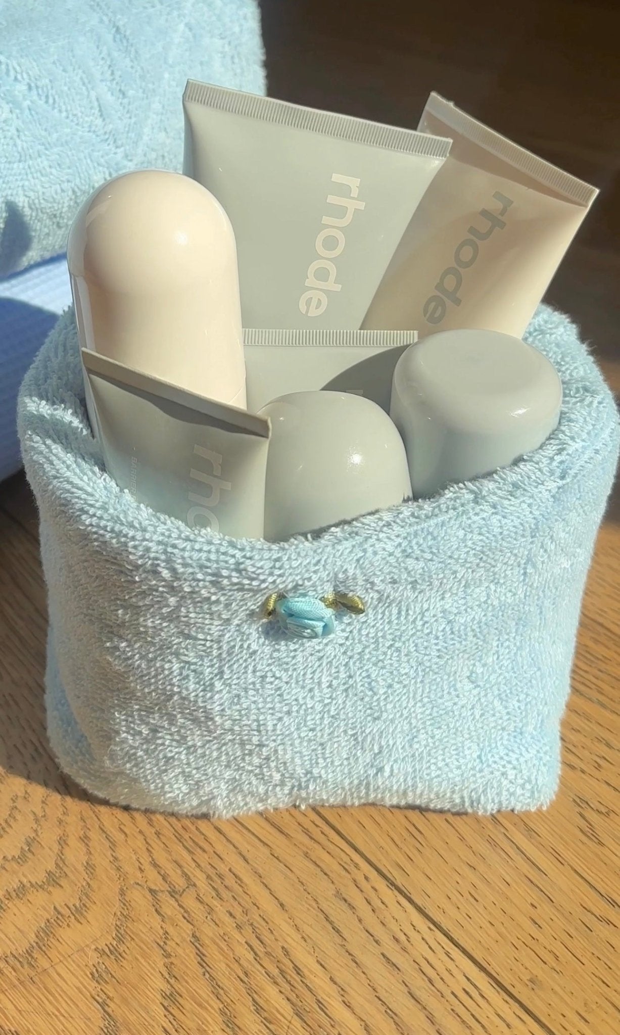Light blue terrycloth organizer with curved white bottles tucked inside