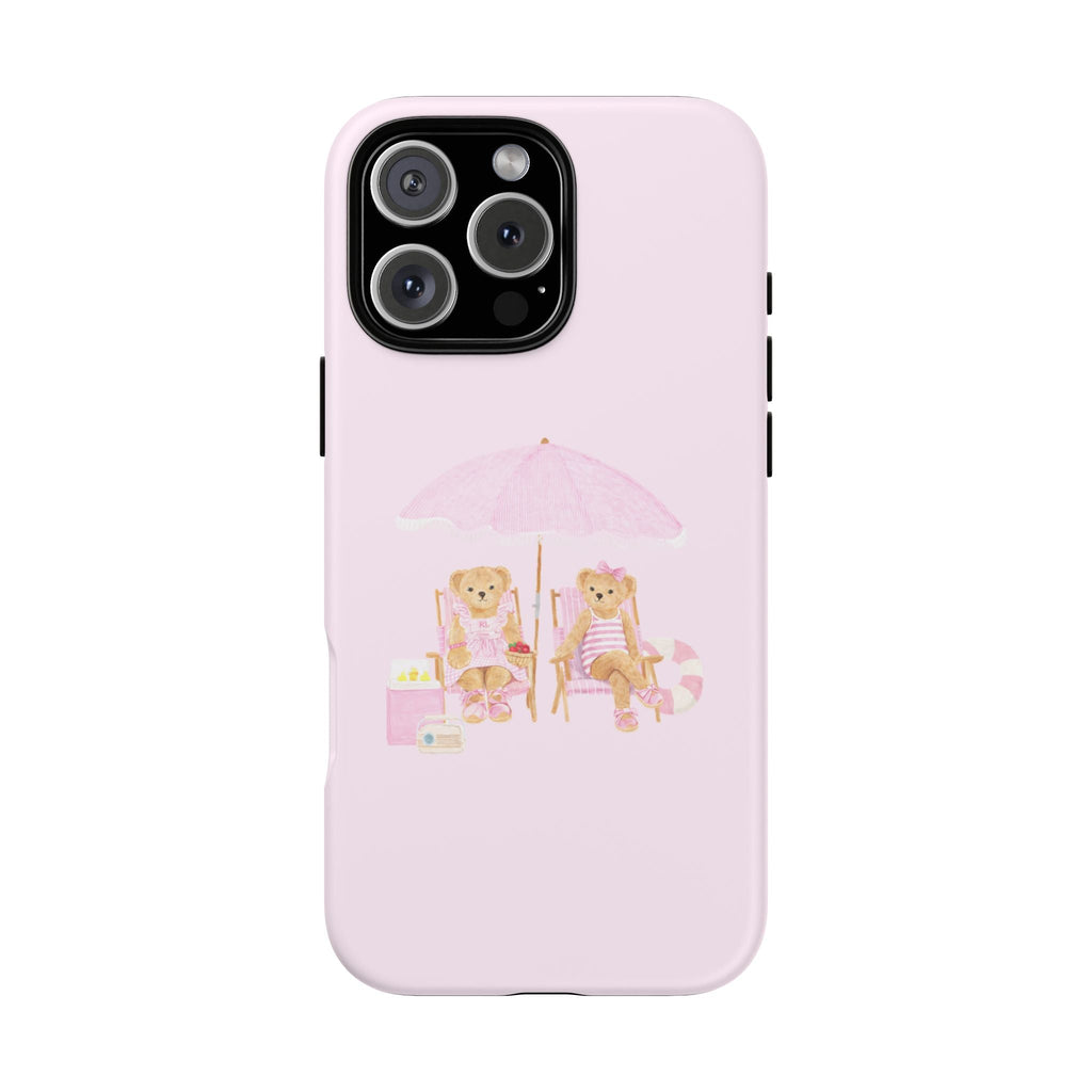Baby pink phone case with two teddy bears at a beach table under a pink umbrella