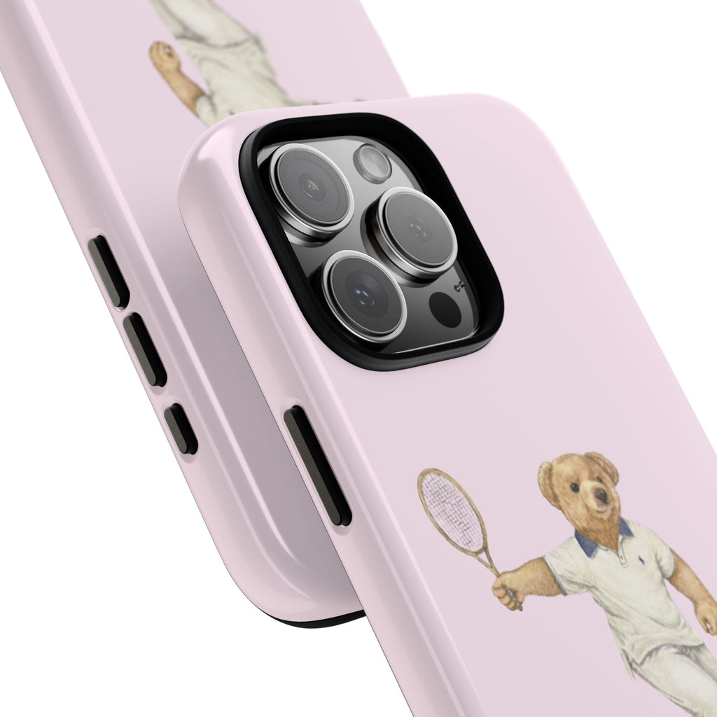 Close-up baby pink phone case showing teddy bear tennis graphic and side button cutouts