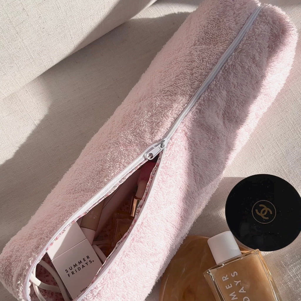 Baby pink terrycloth zip pouch, zipper closed, with interior fabric visible