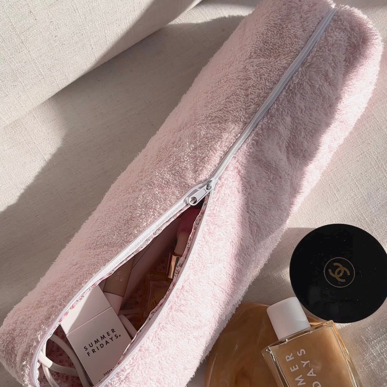 Baby pink terrycloth zip pouch, zipper closed, with interior fabric visible