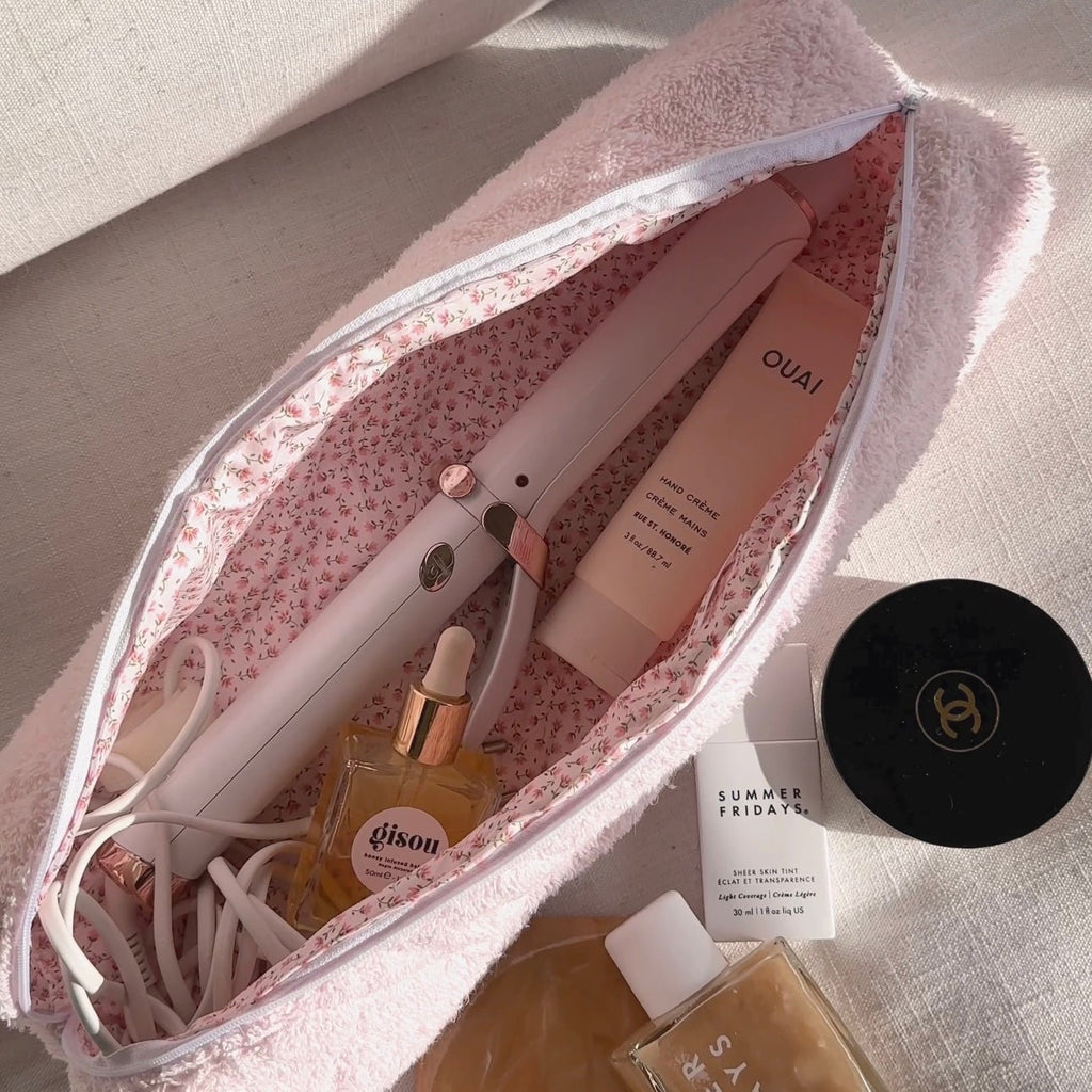 Baby pink terrycloth zip pouch, floral lining, with hair styling tools inside
