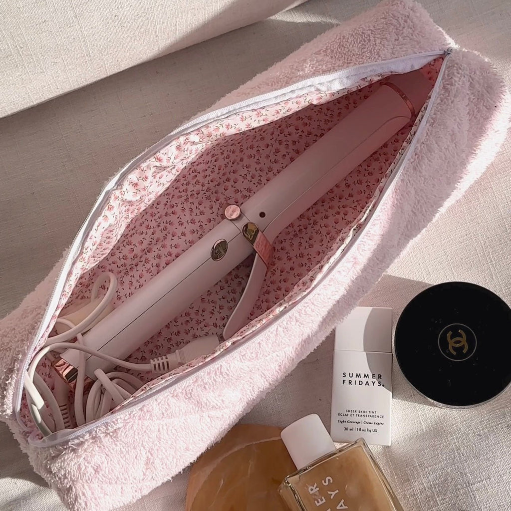 Baby pink terrycloth zip pouch open, showing floral lining and straightener