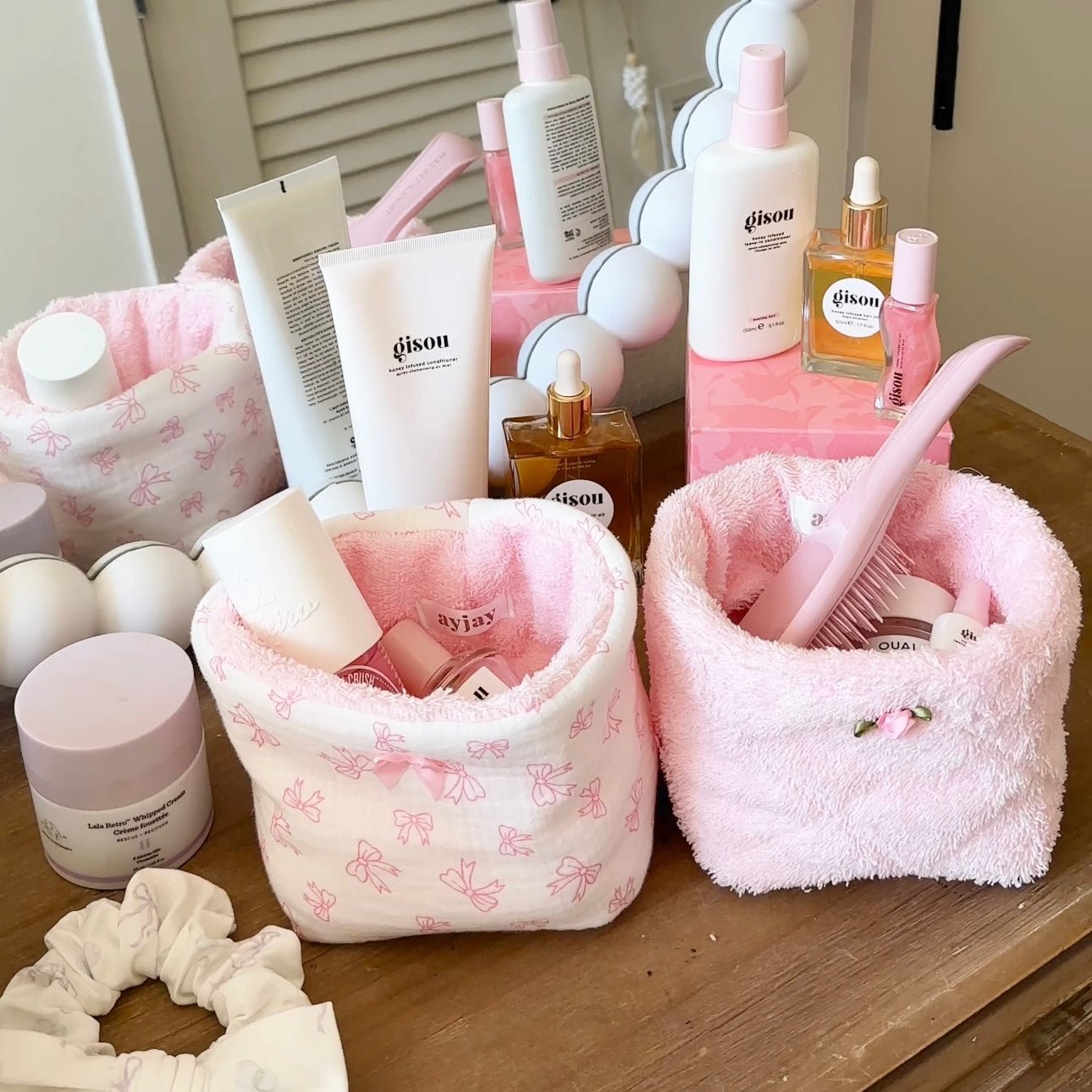 Pink terrycloth organizer bin with bow-pattern outer, open top with toiletries inside