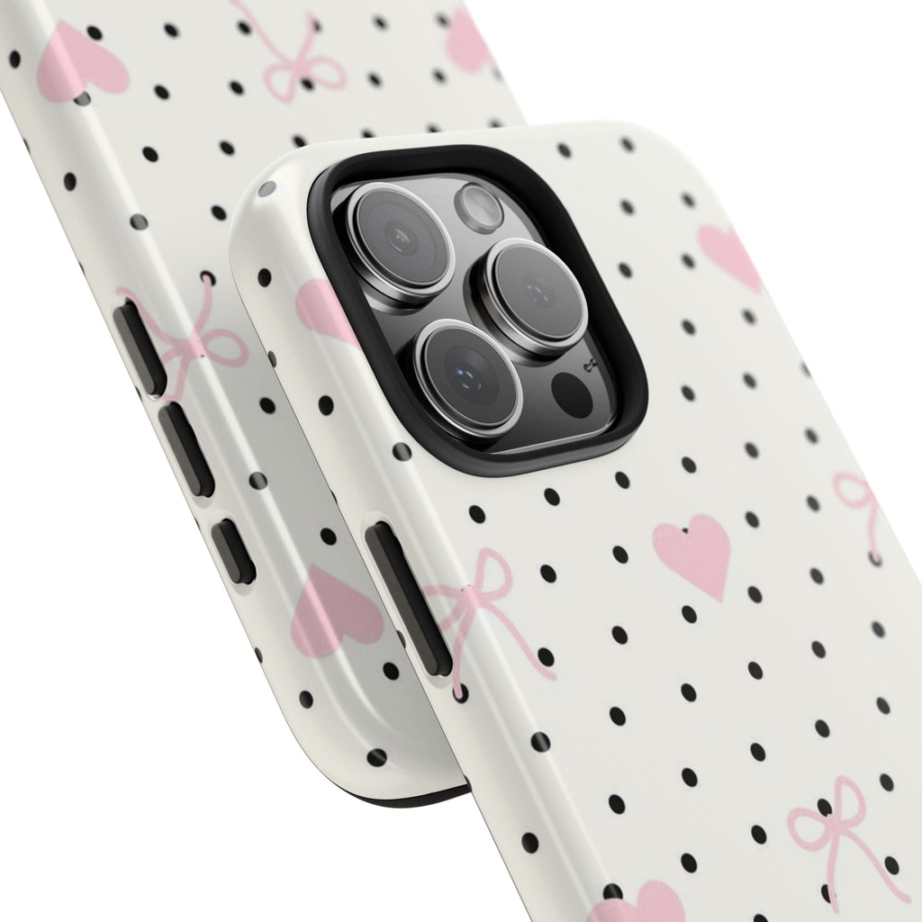 Angle view: white phone case with black polka dots, pink hearts and bow design