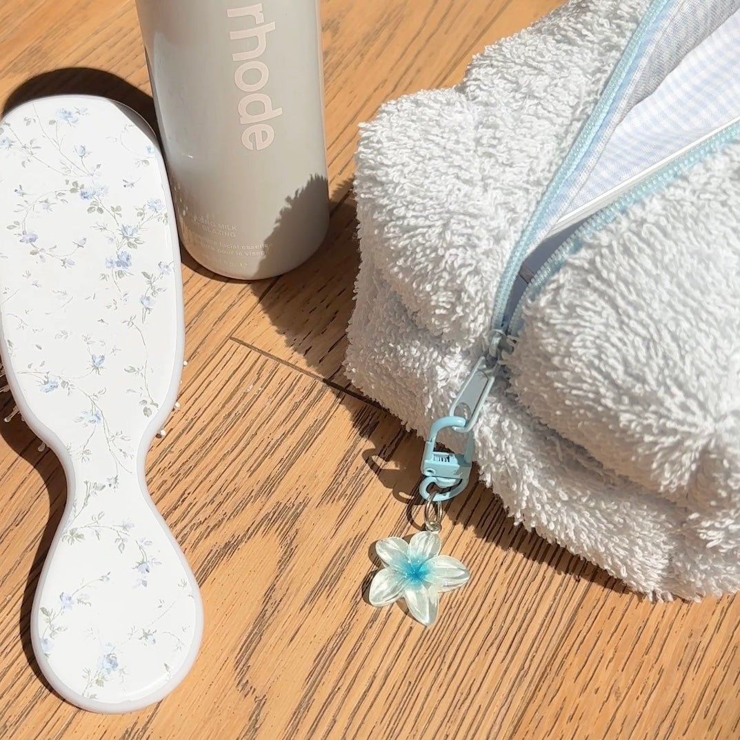 Blue flower bag charm on light blue zipper clip, small star-shaped flower detail