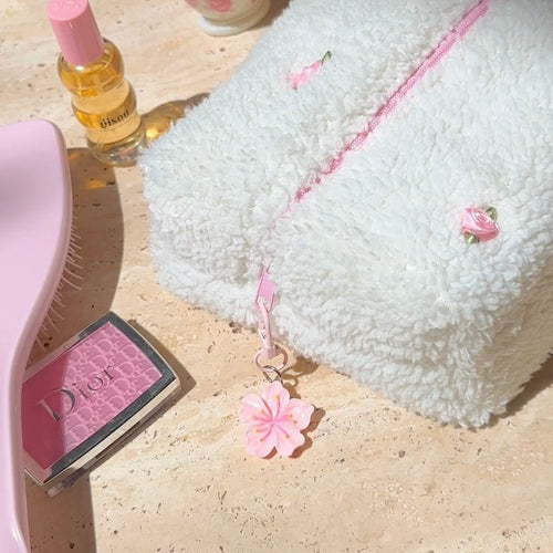 Pink lotus flower bag charm with small clasp on a light strap