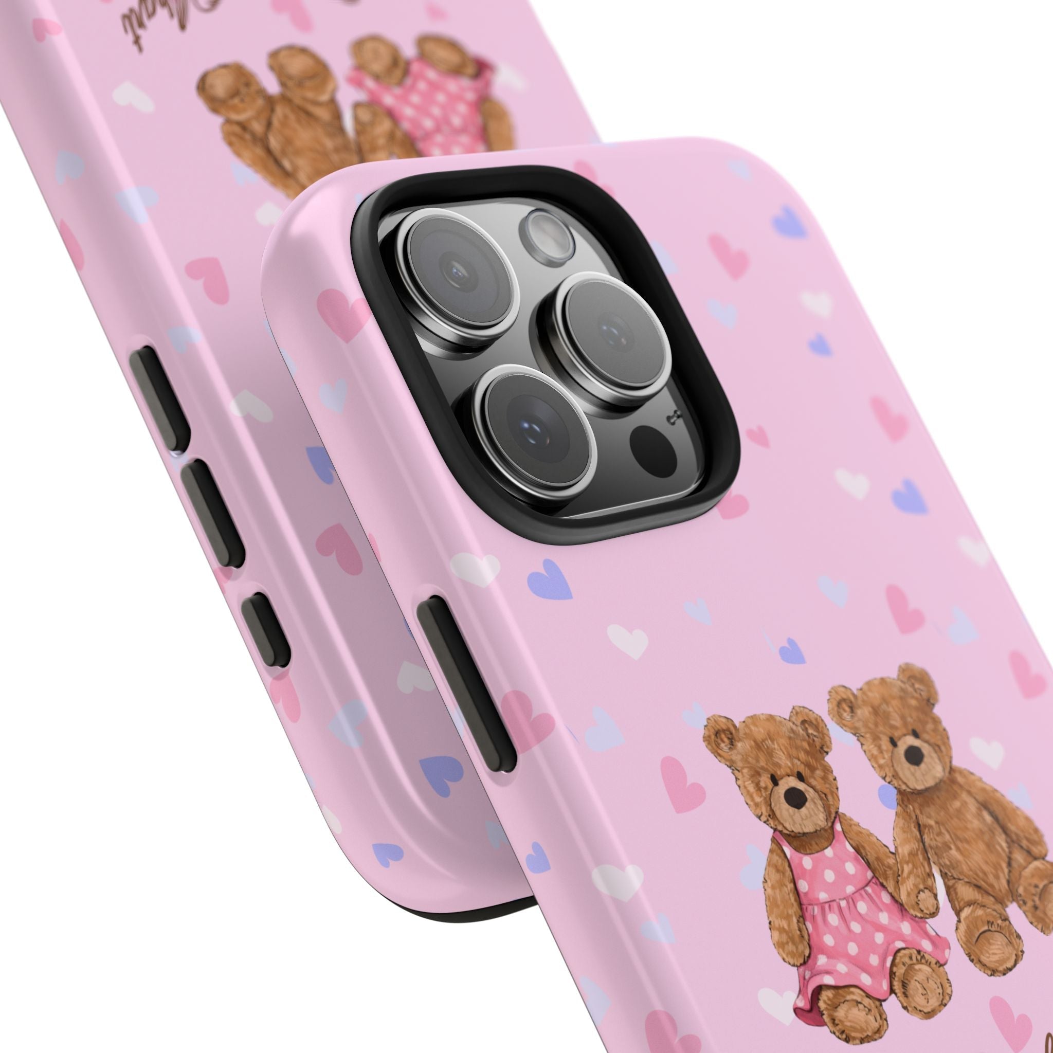 Pink phone case angled with teddy bear design near camera cutouts and hearts