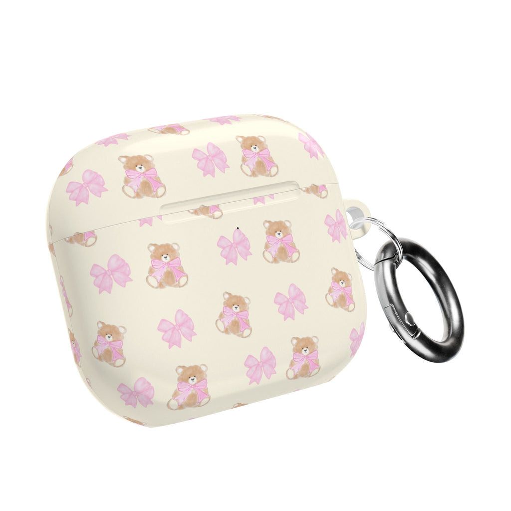Beige AirPods case with teddy bear and pink bow print, with metal keyring