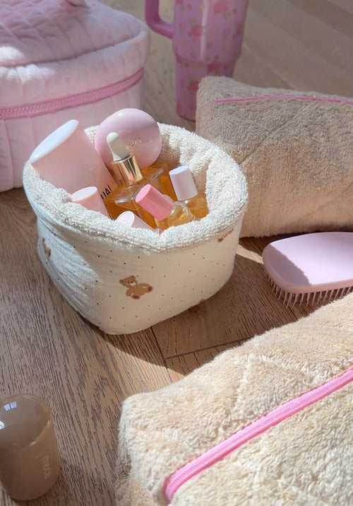 Beige teddy organizer pouch with teddy-bear applique and pink zipper, holds small bottles
