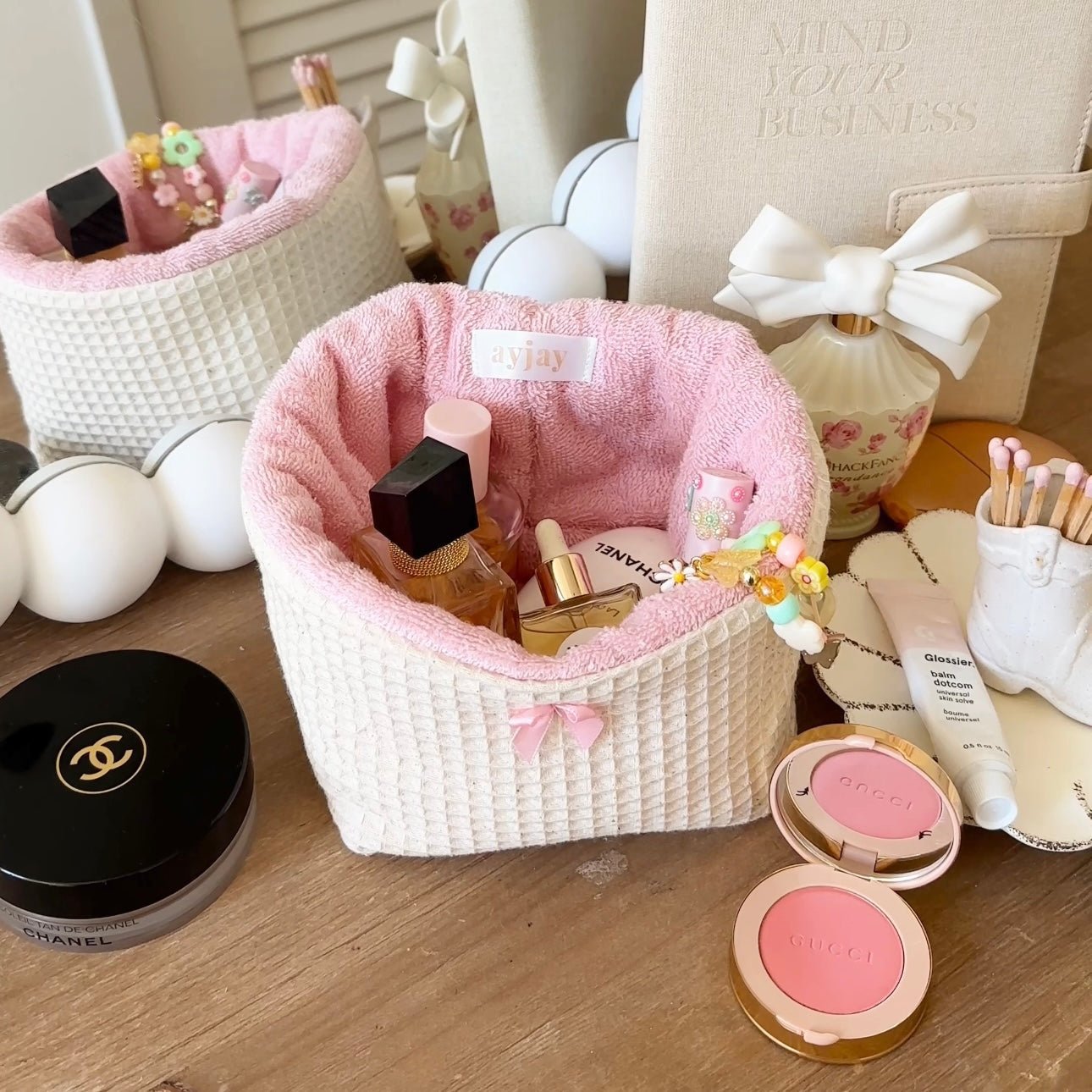 Beige waffle-knit organizer basket with pink lining and white ribbon bow at top