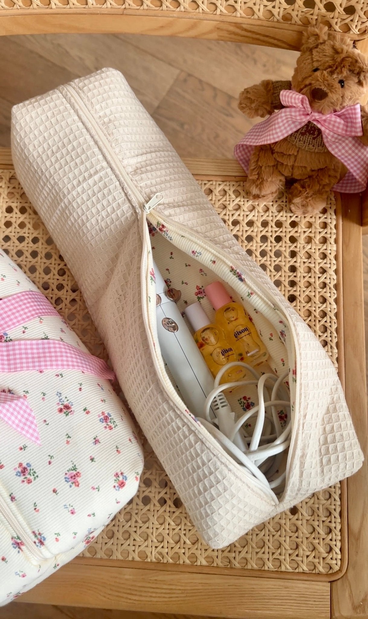 Waffle-texture beige pouch open, showing bottles and chargers; floral lining inside