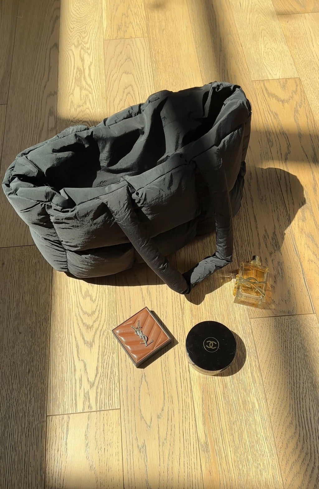 Dark gray quilted puffer duffle tote bag with structured sides and top handle