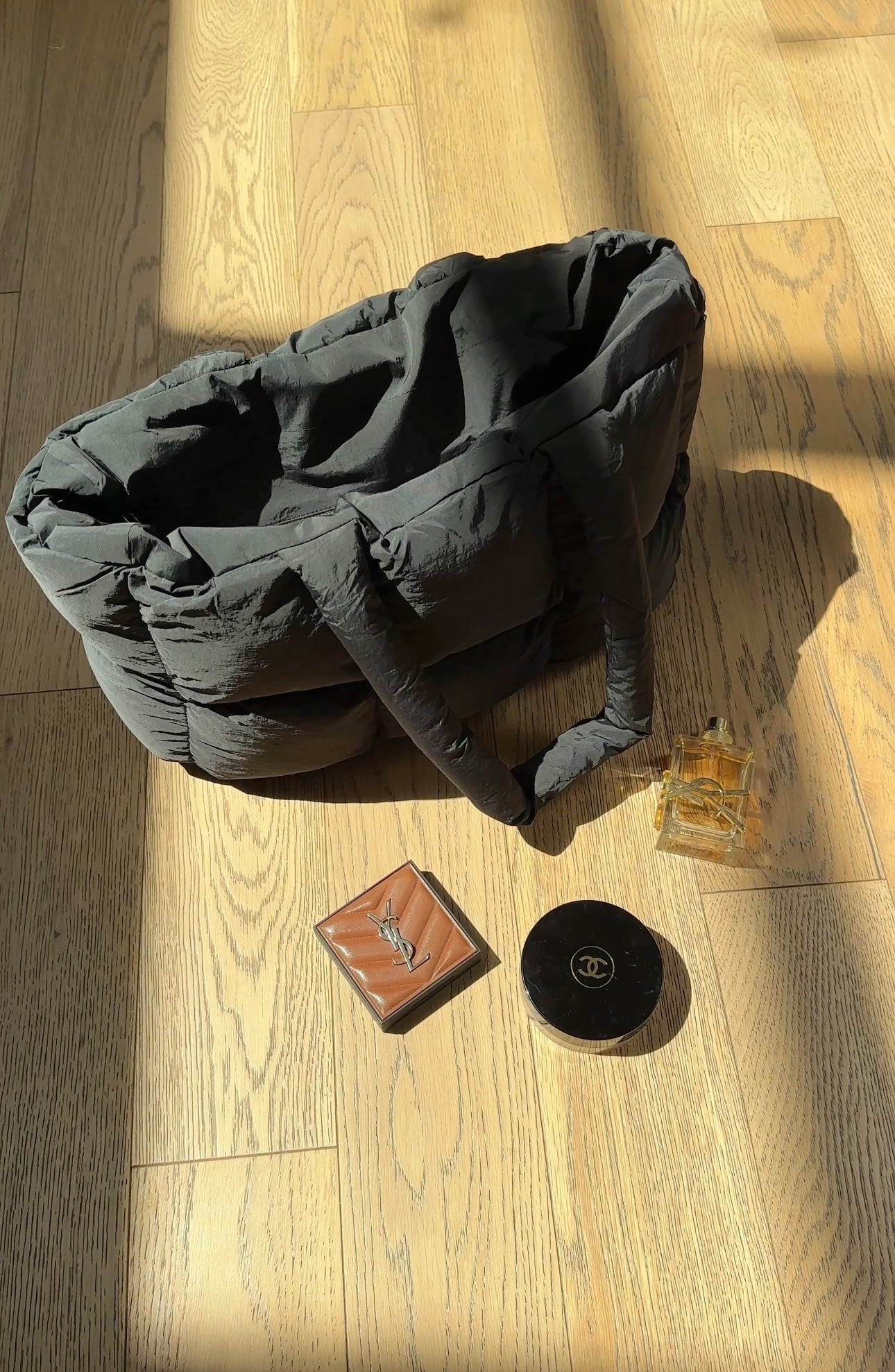 Dark gray quilted puffer duffle tote bag with structured sides and top handle