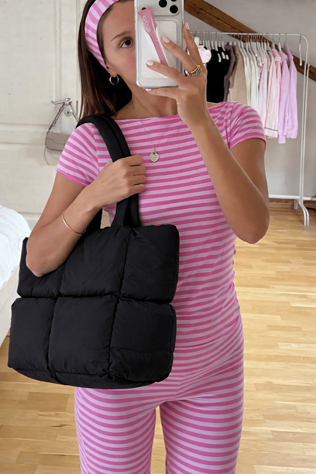 Black quilted puffer tote bag with wide shoulder strap and padded shape