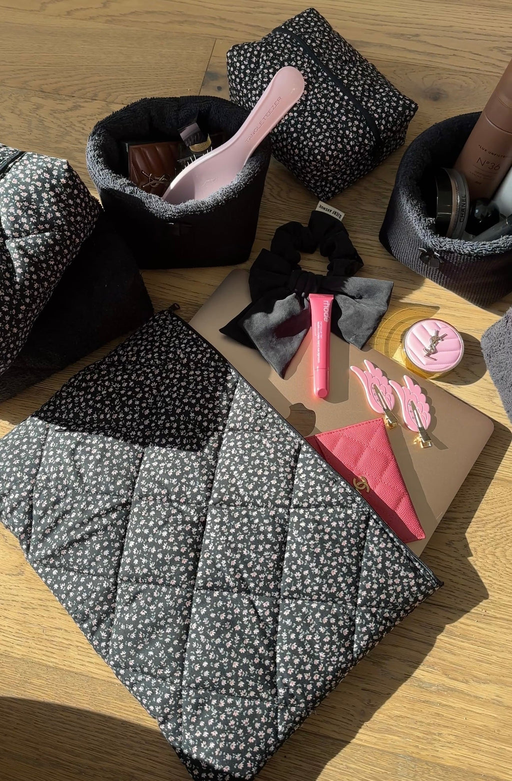 Black ditsy floral zip pouch, open with black lining and pink-toned inside items