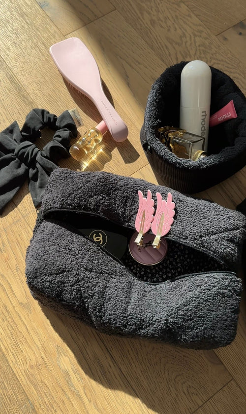 Dark terrycloth zip pouch with pink cactus charm; folded flat for storage
