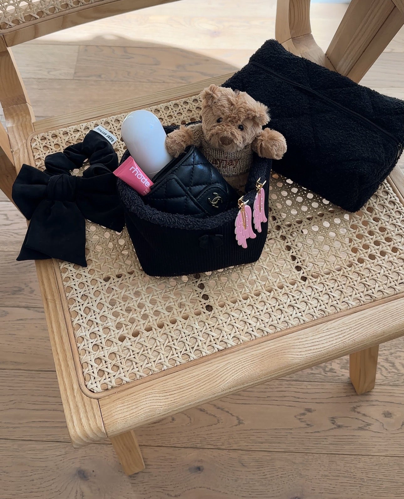 Black waffle-knit organizer basket with plush-lined rim, holding small bottles and cards