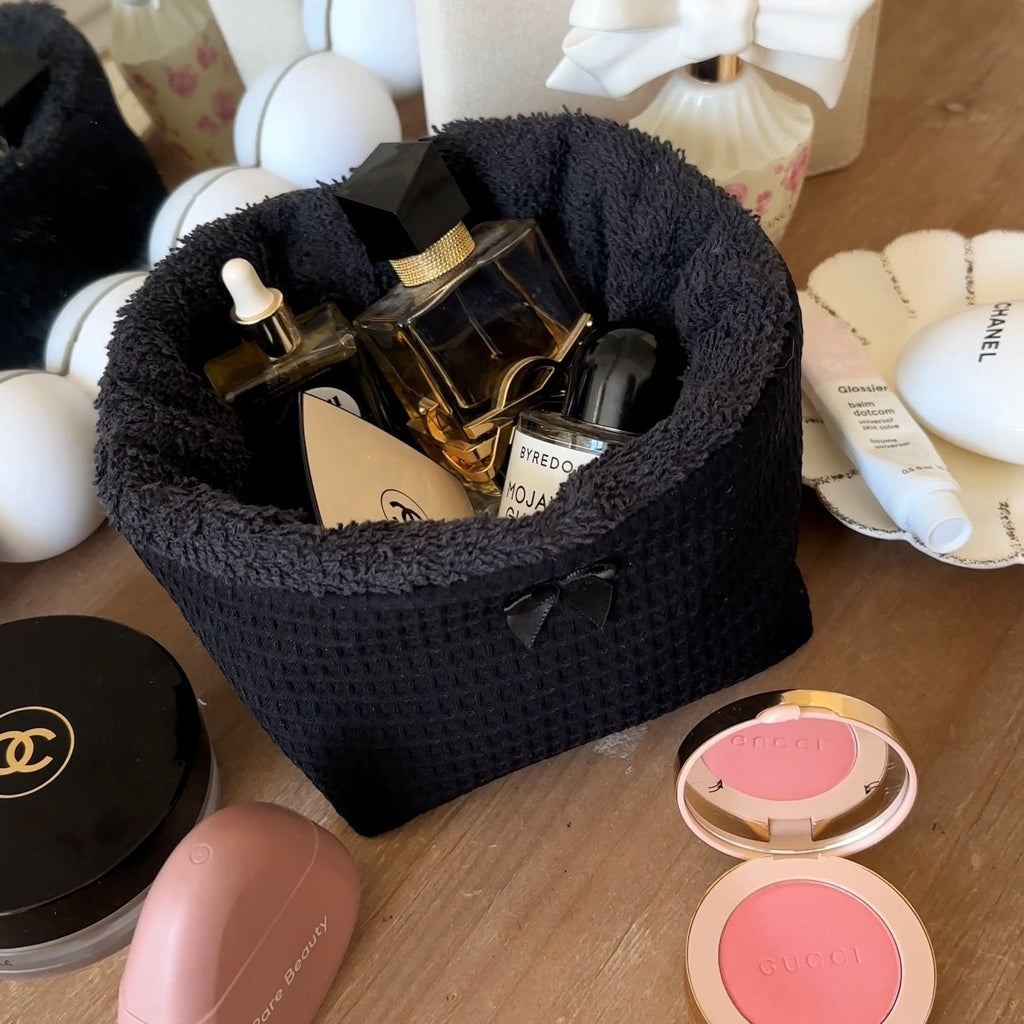 Black waffle-knit organizer basket with plush rim, holds perfume and makeup compacts