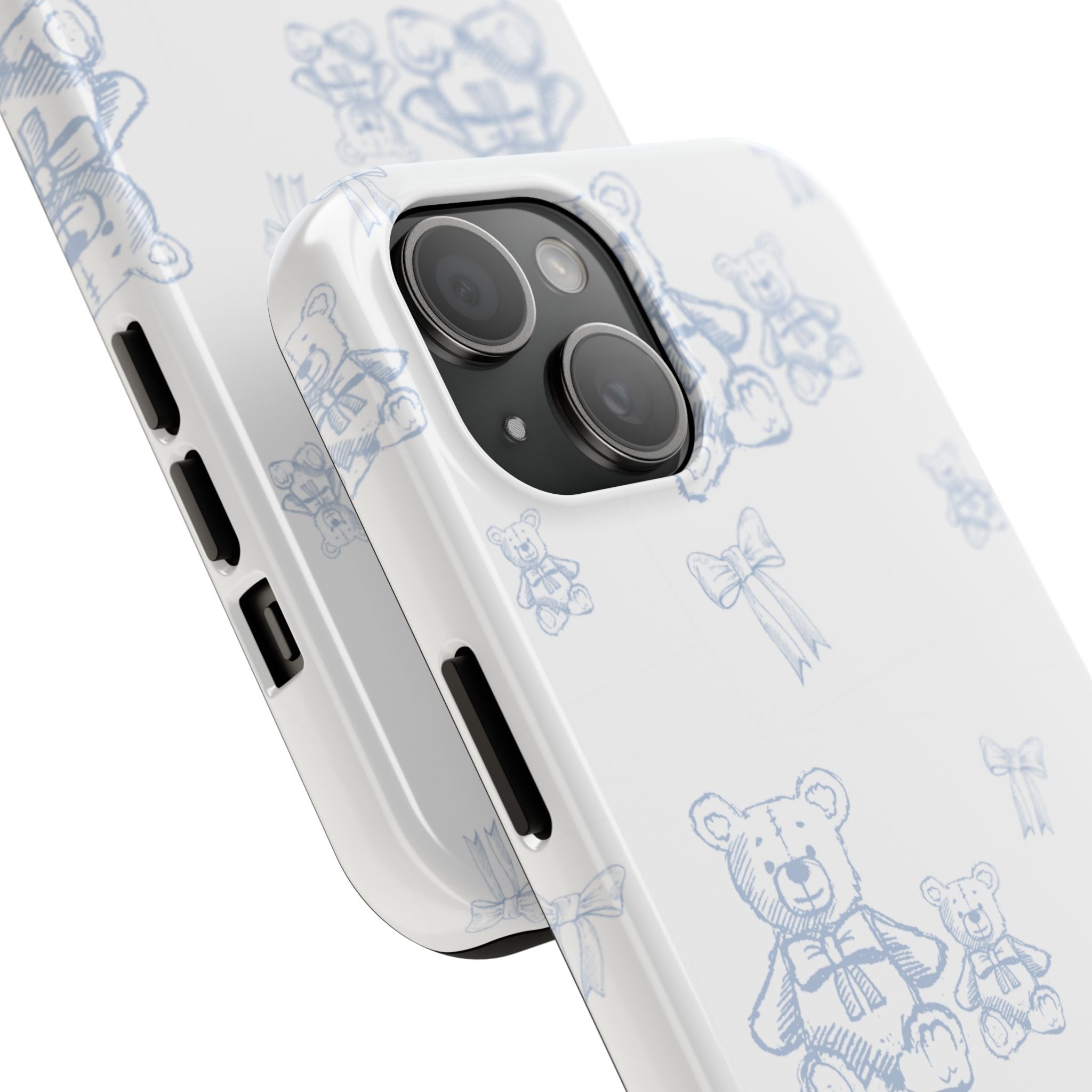 White phone case with blue teddy bear and ribbon pattern, angled near camera lenses