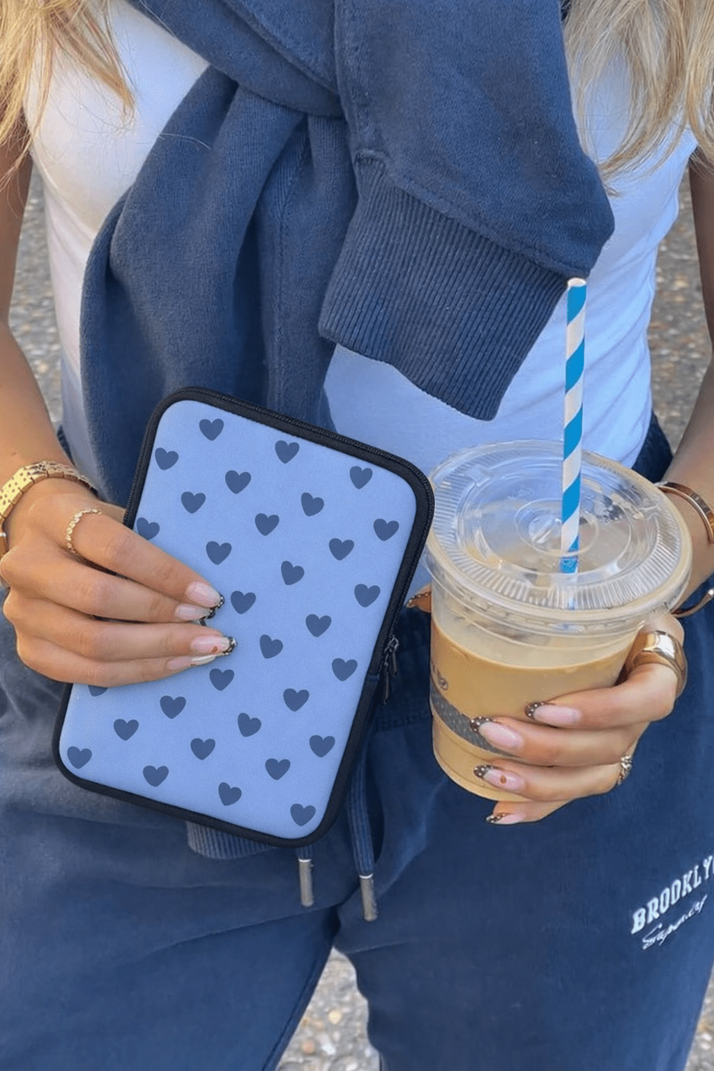 Blue neoprene device sleeve with dark heart pattern and black zip cords