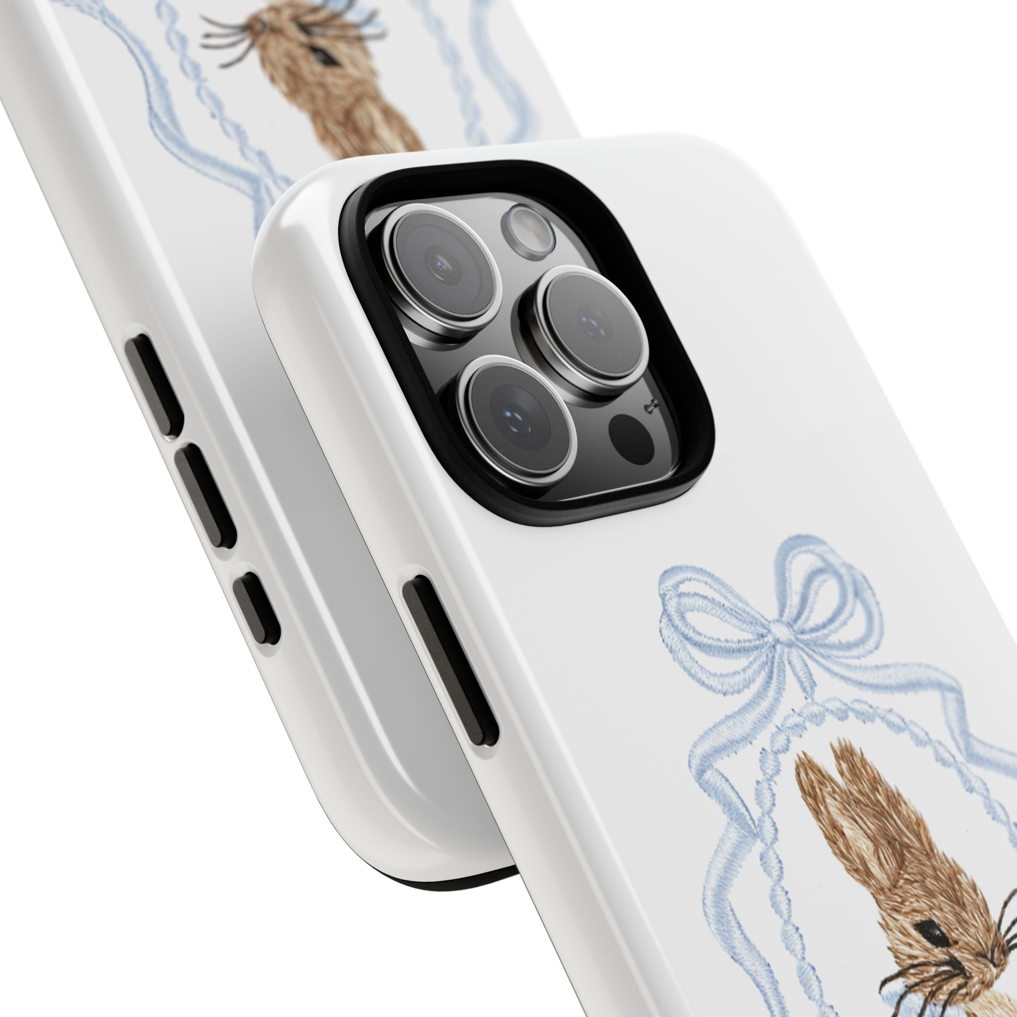 Angled view: white phone case with blue ribbon bow and brown bunny illustration near corner