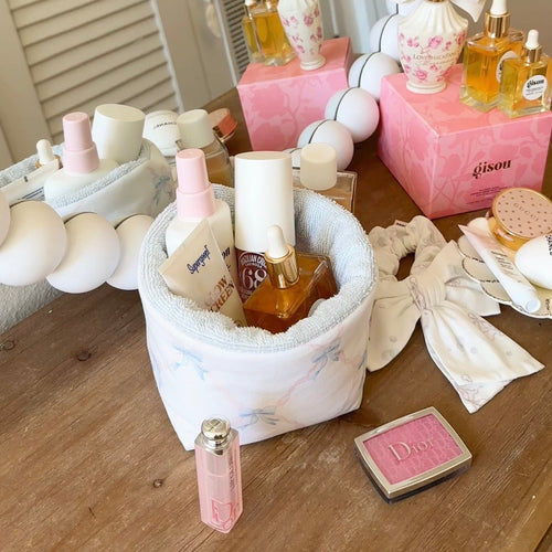 White round organizer pouch with blue floral trim, toiletries bottles and jars arranged inside