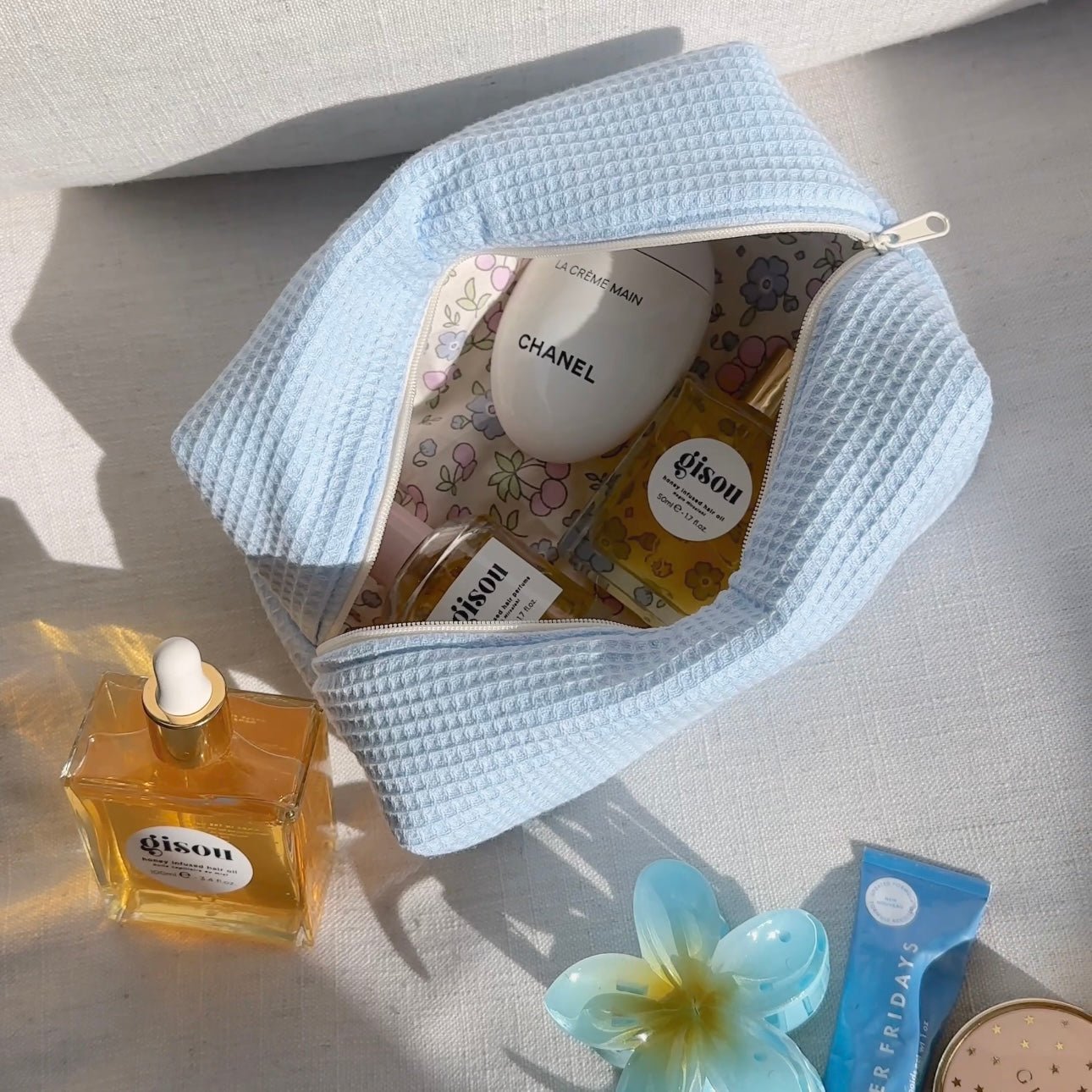 Light blue waffle-knit zip pouch with floral-lined interior, open